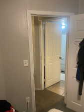Corridor with light tile patterned floors and light carpet. APT 2