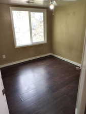 Empty room featuring dark wood finished floors and ceiling fan. APT 3