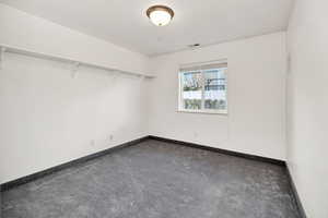 Carpeted empty room featuring baseboards