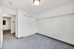 Unfurnished bedroom featuring carpet and a closet