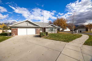 Ranch-style home featuring brick siding, concrete driveway, and an attached garage