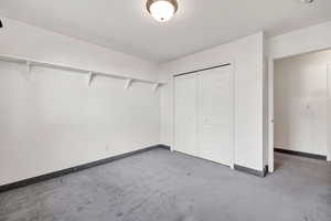 Unfurnished bedroom featuring carpet floors and a closet