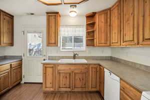 Kitchen with open shelves, dishwasher, brown cabinets, and light wood-style floors
