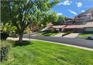 View of asphalt road with a residential view, curbs, and sidewalks