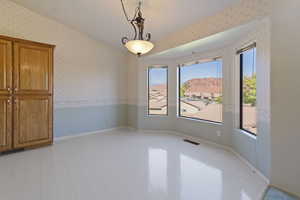 Dine with beautiful redrock views featuring wainscoting, a mountain view, and wallpapered walls