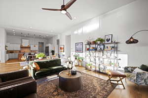 Living room with light wood finished floors, recessed lighting, and ceiling fan
