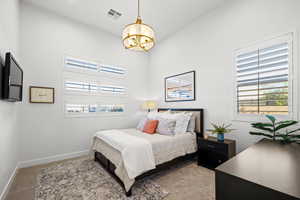 Bedroom featuring light carpet and a chandelier