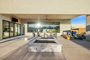 View of patio featuring a ceiling fan and an outdoor living space with a fire pit