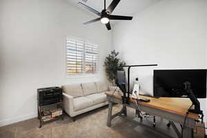 Carpeted office with baseboards and a ceiling fan