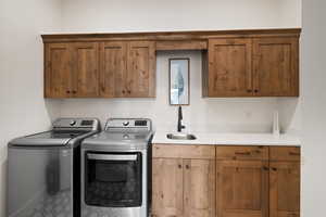 Laundry room featuring washer and clothes dryer and cabinet space