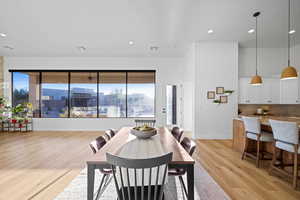 Dining space with healthy amount of natural light, light wood-style floors, and recessed lighting