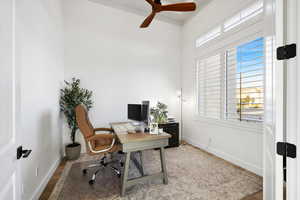 Home office featuring light wood-style floors and a ceiling fan