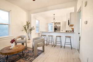 Sitting room with light wood finished floors and a chandelier