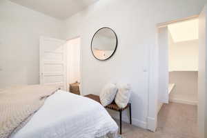Bedroom featuring light carpet and baseboards