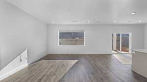 Spare room featuring dark wood-type flooring and recessed lighting