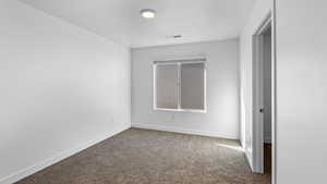 Carpeted empty room with baseboards and a textured ceiling