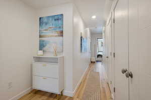 Hallway featuring light wood finished floors and recessed lighting