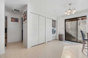 Laundry area featuring tile patterned floors, washer / clothes dryer, and a chandelier