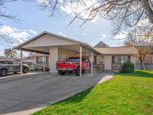 View of front of property with driveway and a carport