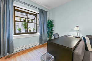 Home office featuring light wood-type flooring and a baseboard radiator