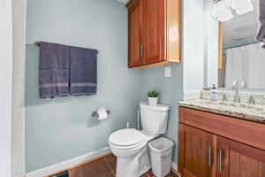 Bathroom featuring curtained shower, dark tile patterned floors, and vanity