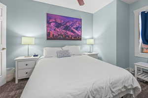 Bedroom with dark colored carpet and ceiling fan
