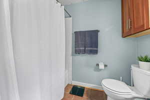 Bathroom with tile patterned floors and shower / bath combo with shower curtain