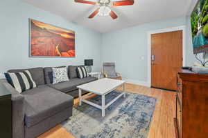 Living room with light wood-style floors and ceiling fan