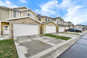 Craftsman house featuring board and batten siding, stone siding, and concrete driveway