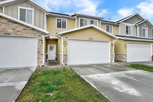 Craftsman-style house featuring board and batten siding, stone siding, and concrete driveway