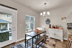 Dining area with a chandelier and light wood-style flooring