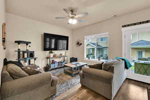 Living room featuring wood-type flooring and a ceiling fan