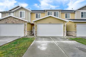 Craftsman-style home featuring stone siding, board and batten siding, driveway, and a garage
