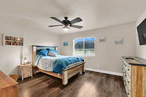 Bedroom with ceiling fan and dark wood-style floors