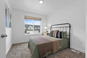 Bedroom featuring carpet and baseboards