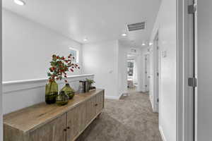 Corridor with dark carpet and recessed lighting