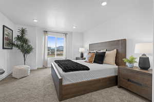 Bedroom with light colored carpet, recessed lighting, and a mountain view