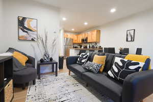 Living area with recessed lighting and light wood-style flooring