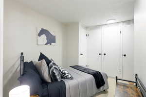 Bedroom with a closet, a textured ceiling, and baseboard heating