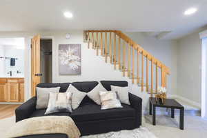 Living room with recessed lighting and stairs