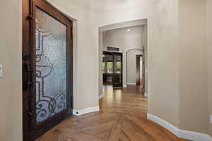Hallway featuring recessed lighting, parquet flooring, and arched walkways