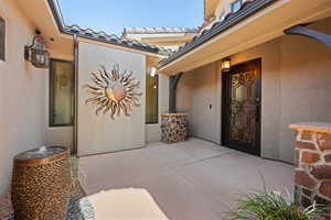Doorway to property featuring a patio and stucco siding