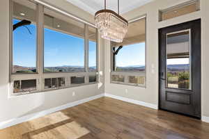 Unfurnished dining area with a mountain view, hardwood / wood-style flooring, and a chandelier