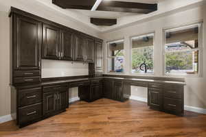 Unfurnished office with built in study area and dark wood finished floors