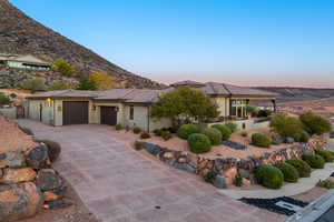 View of front of home featuring a garage, stucco siding, driveway, and a tiled roof