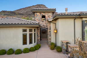 View of exterior entry with stone siding and stucco siding