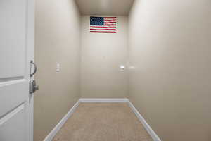 Washroom featuring light colored carpet and baseboards
