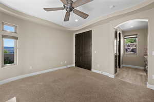 Unfurnished bedroom featuring light carpet, arched walkways, a closet, recessed lighting, and ceiling fan