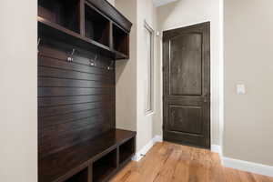 Mudroom featuring light wood finished floors and baseboards