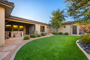 Back of property with a patio, stucco siding, a yard, and a tiled roof